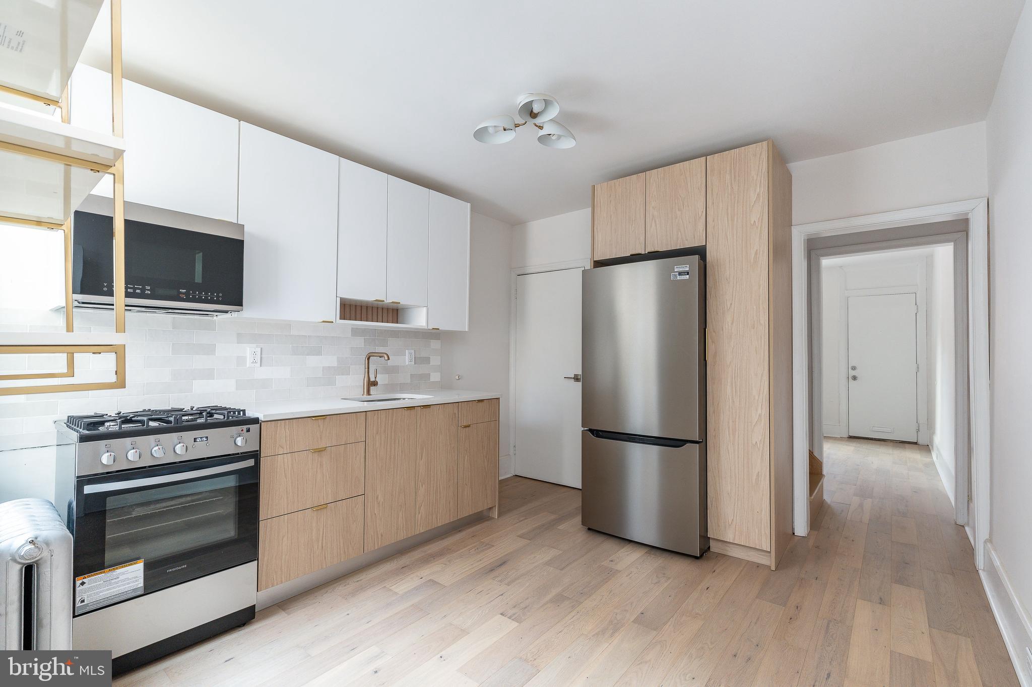 a kitchen with stainless steel appliances granite countertop a refrigerator stove and microwave