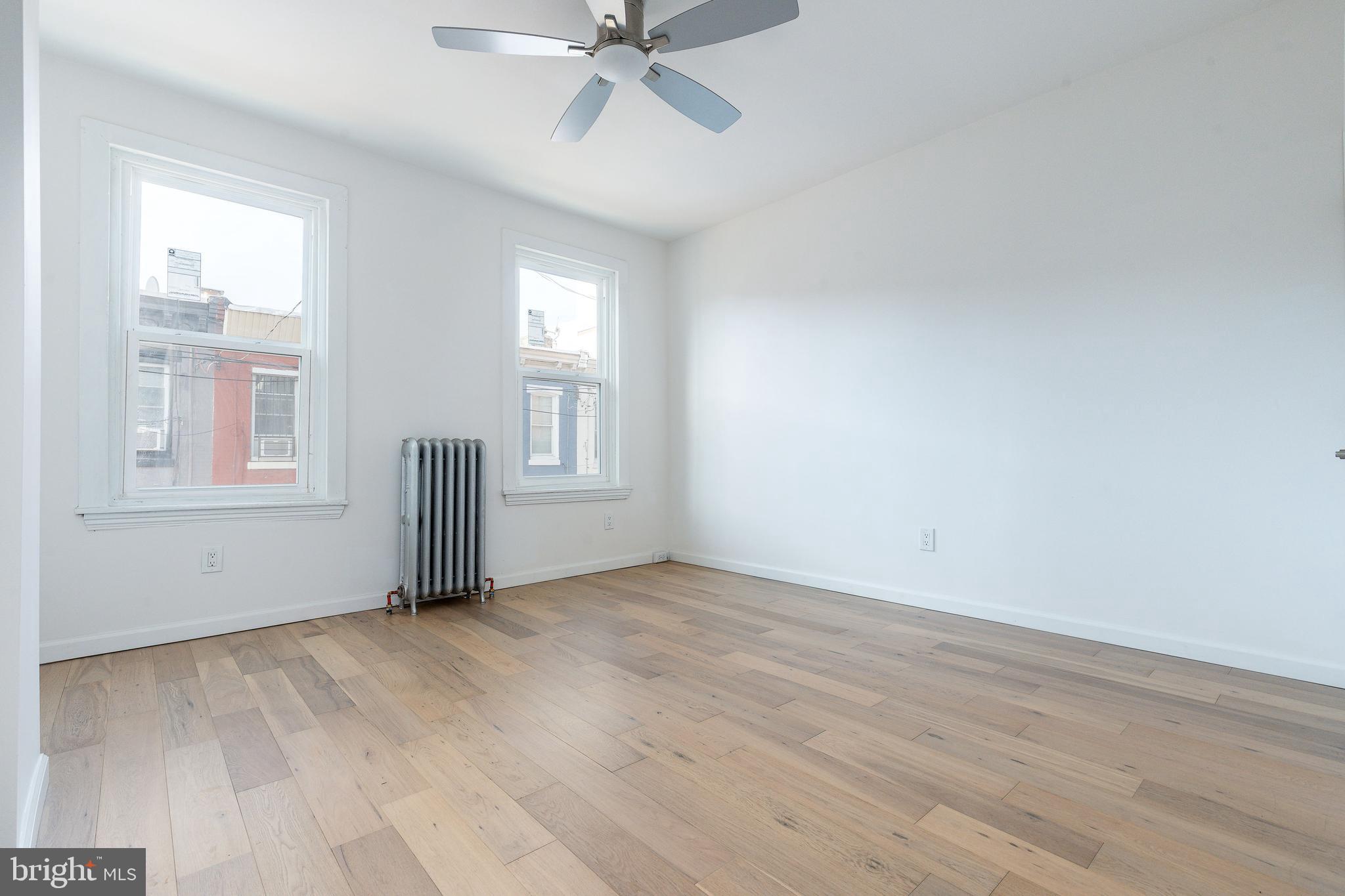 2143 Palethorp Street Philadelphia, PA 19122 - Photo 12 of 27 an empty room with wooden floor fan and windows