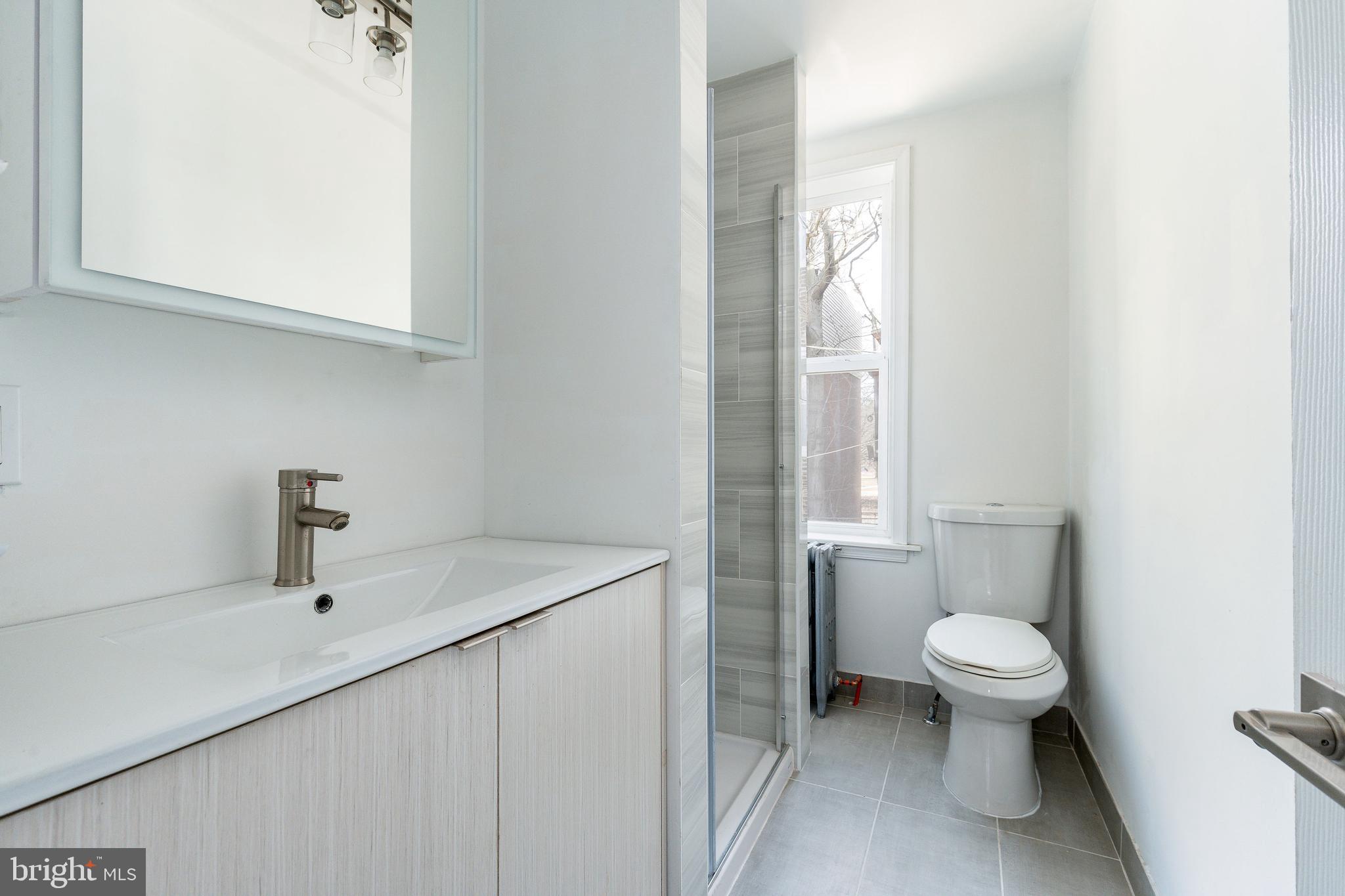 2143 Palethorp Street Philadelphia, PA 19122 - Photo 16 of 27 a bathroom with a sink a toilet and a mirror