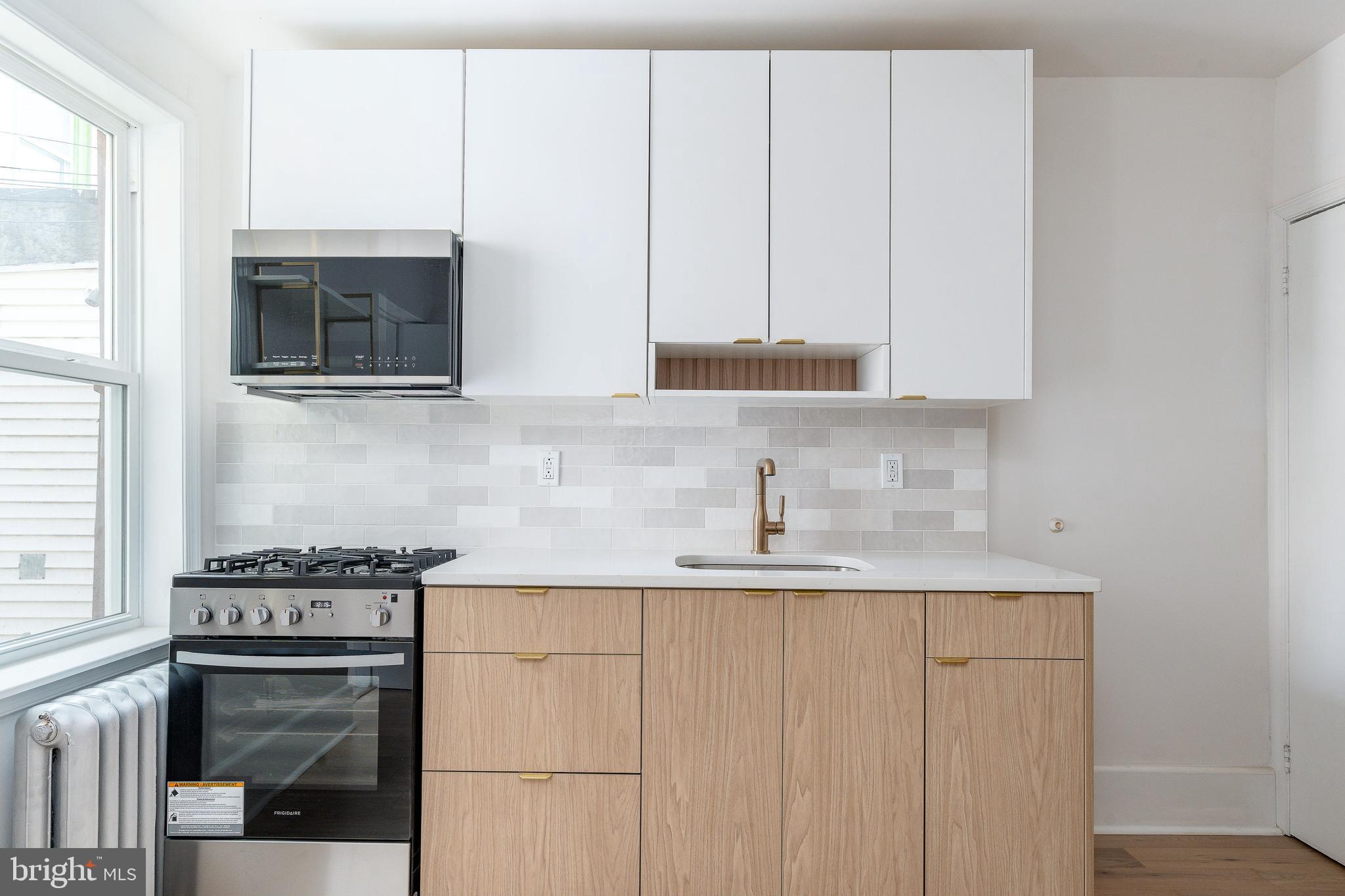 2143 Palethorp Street Philadelphia, PA 19122 - Photo 3 of 27 a kitchen with granite countertop white cabinets and stainless steel appliances