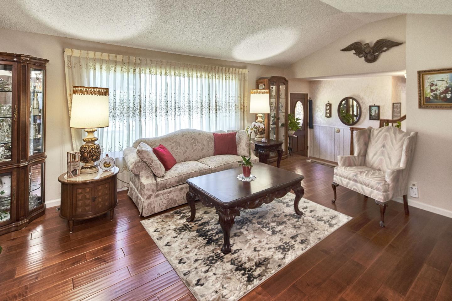 763 Upton Way San Jose, CA 95136 - Photo 7 of 32 a living room with furniture a lamp wooden floor and a large window