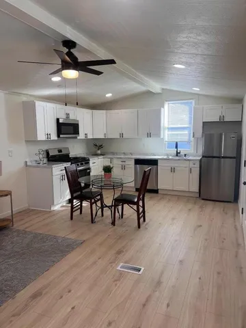 a kitchen with a table chairs microwave and cabinets
