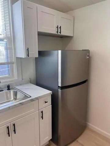 a kitchen with refrigerator and cabinets