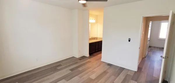 wooden floor in an empty room with a bathroom