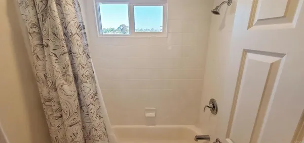 a bathroom with a bathtub and shower