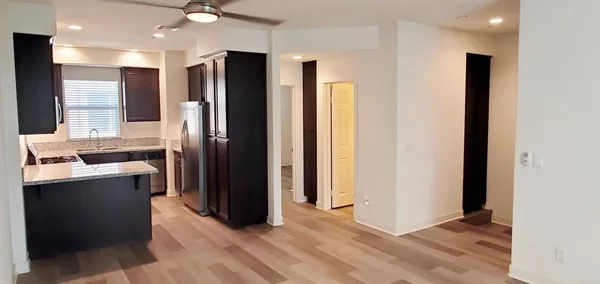 a view of kitchen with stainless steel appliances granite countertop a refrigerator and a sink