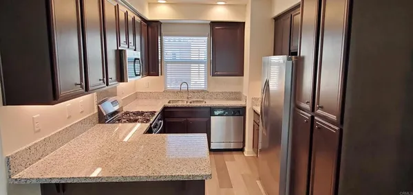 a kitchen with stainless steel appliances granite countertop a refrigerator and a stove