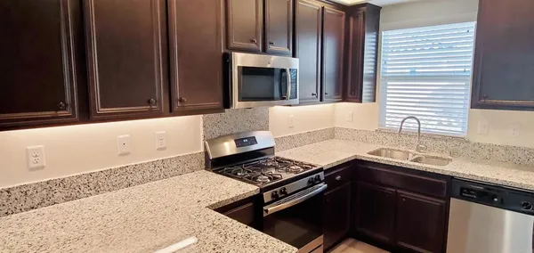 a kitchen with a sink cabinets and black stainless steel appliances
