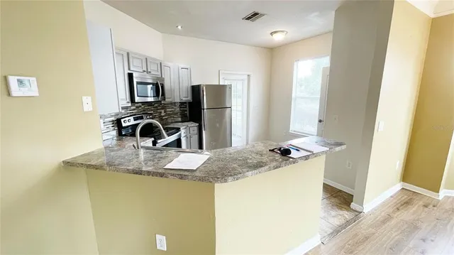 a kitchen with stainless steel appliances granite countertop a sink stove and refrigerator
