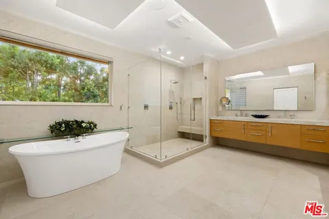 a spacious bathroom with a bathtub sink and mirror