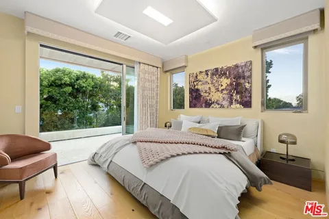 a bedroom with a bed and a large window