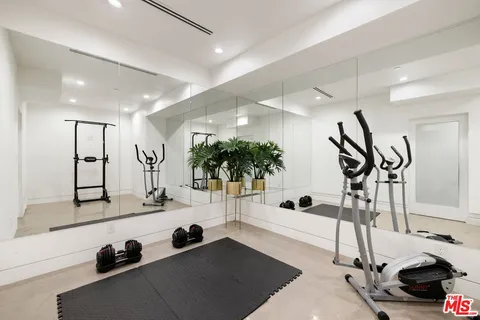a view of gym equipment and living room with windows