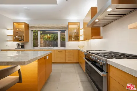 a large kitchen with stainless steel appliances granite countertop a stove and a sink