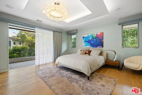 a bed sitting in a spacious bedroom next to a window