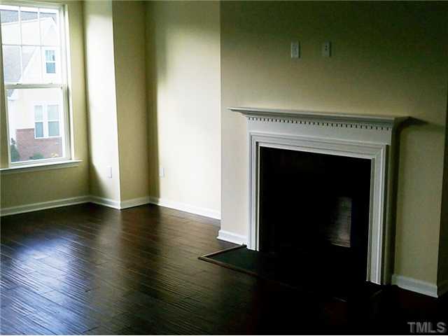 1311 Rodessa Run Raleigh, NC 27607 - Photo 2 of 4 a view of an empty room with wooden floor and a window