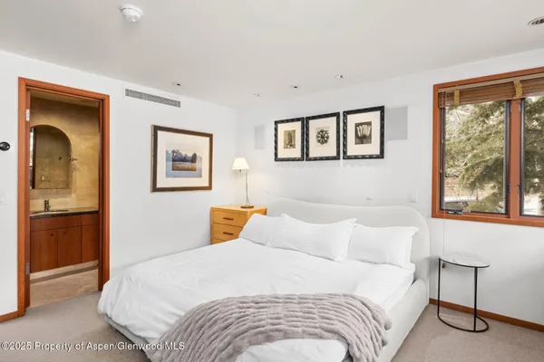 a bedroom with a bed and a painting on the wall