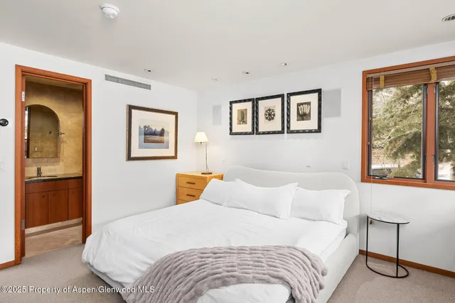 a bedroom with a bed and a painting on the wall