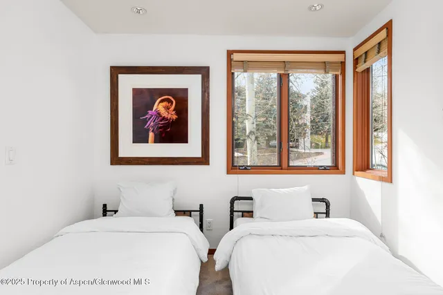 a bedroom with 2 bed and a window