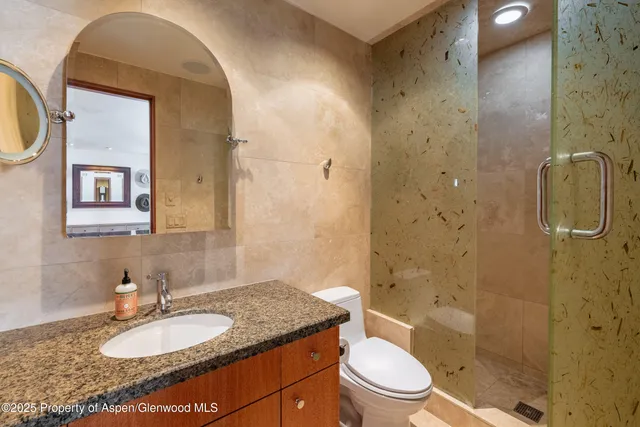 a bathroom with a granite countertop sink toilet and shower