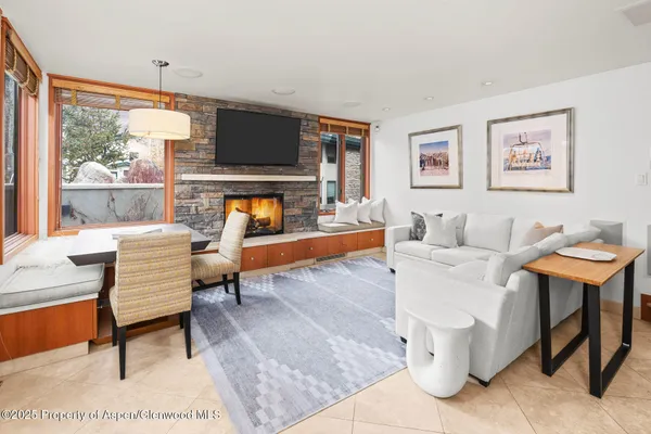 a living room with furniture a flat screen tv and a floor to ceiling window