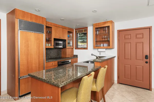 a kitchen with stainless steel appliances granite countertop a sink refrigerator and microwave