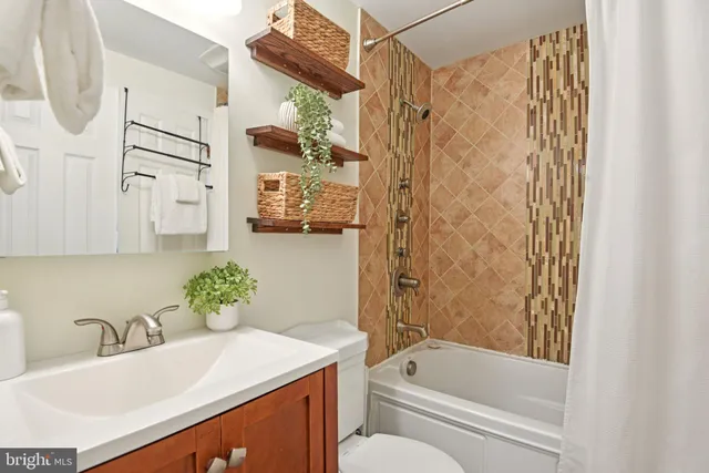 a bathroom with a granite countertop sink a toilet and shower