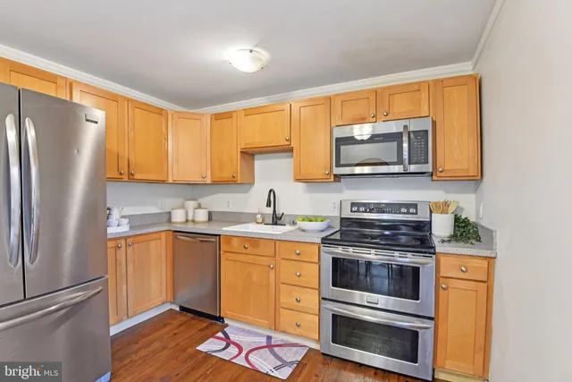 a kitchen with stainless steel appliances a stove a sink and a microwave