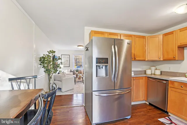 a kitchen with stainless steel appliances a refrigerator a sink a stove a dining table and chairs