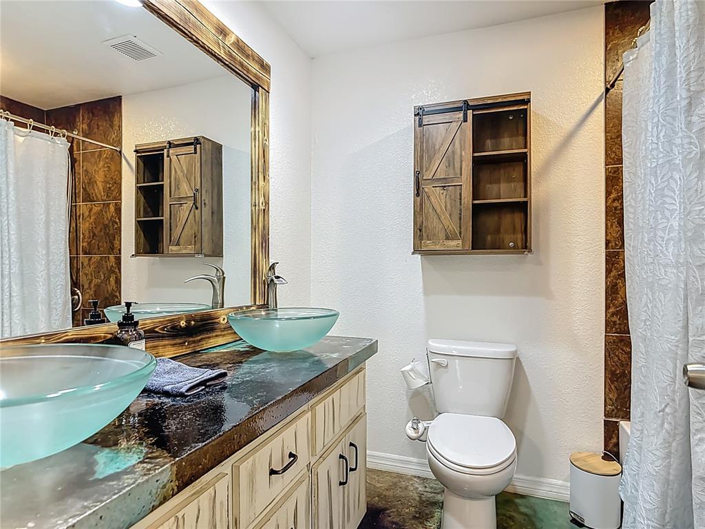3114 Southeast Brown Road Arcadia, FL 34266 - Photo 30 of 61 a bathroom with a granite countertop sink toilet and mirror