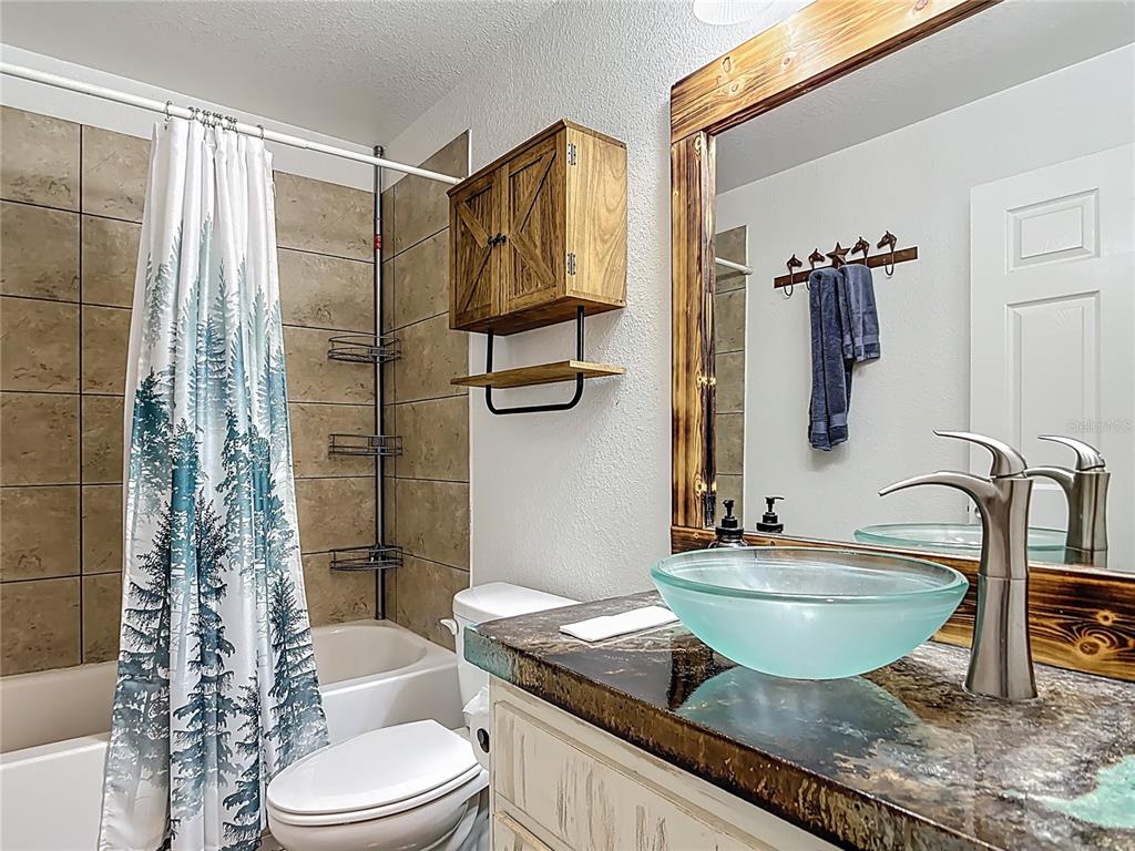 3114 Southeast Brown Road Arcadia, FL 34266 - Photo 34 of 61 a bathroom with a granite countertop sink a toilet a mirror and shower