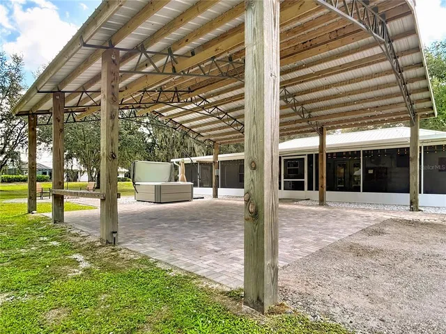 a view of a backyard with table and chairs and potted plants with large trees