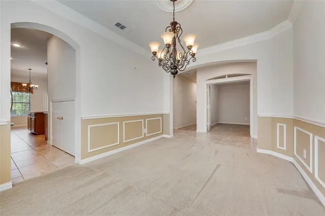 a view of a livingroom with a chandelier fan and windows
