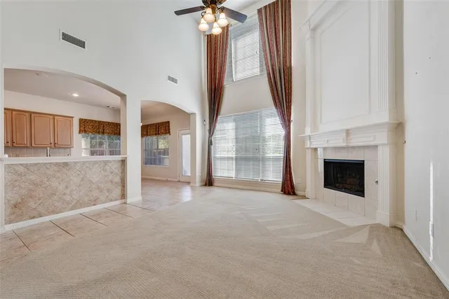 an empty room with windows and fireplace