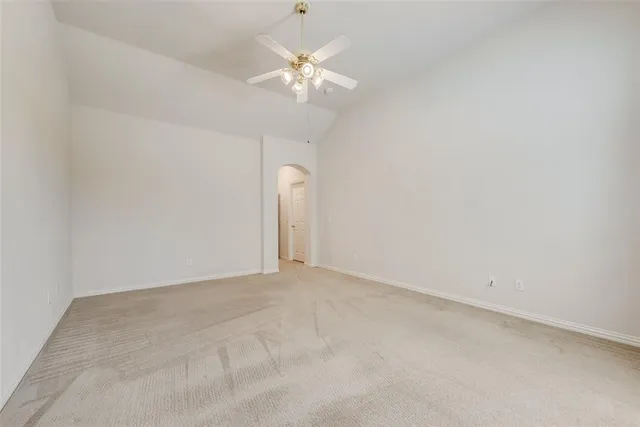 an empty room with a chandelier fan and a chandelier fan