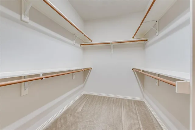 a view of walk in closet with empty racks