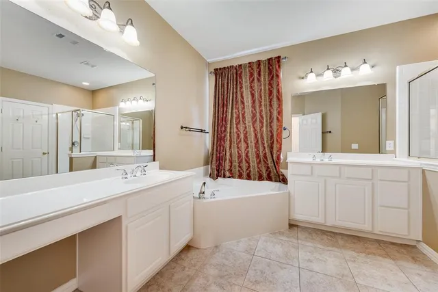 a bathroom with a sink double vanity mirror and a bathtub