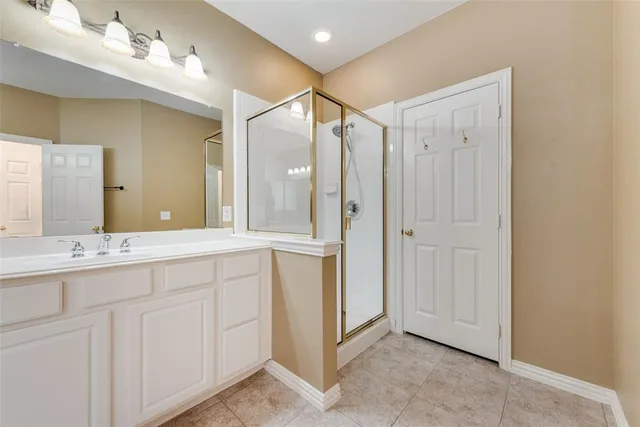 a spacious bathroom with a shower sink and mirror