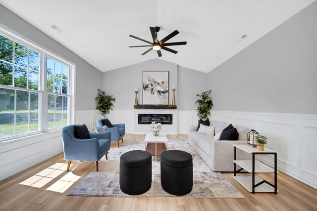a living room with furniture a fireplace and a large window