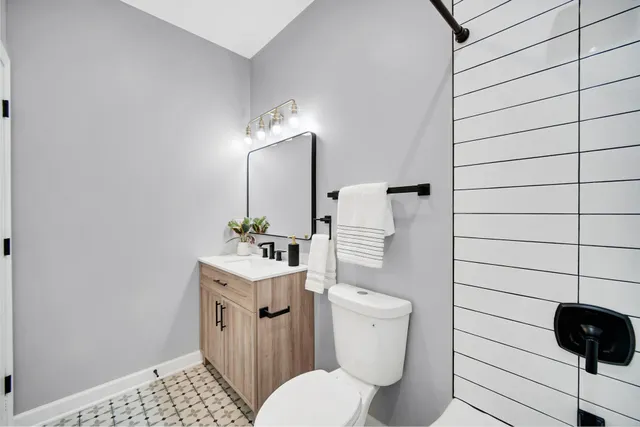 a bathroom with a toilet a sink and mirror