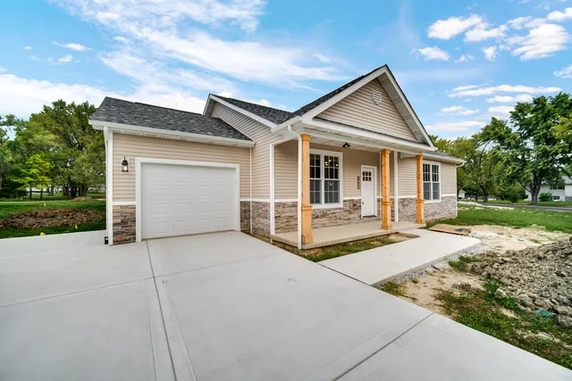 a view of house with backyard and trees in the background