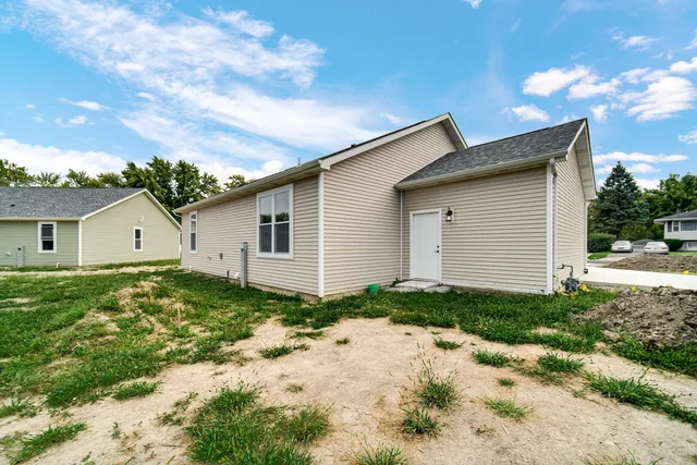 a backyard of a house with plants and a garage