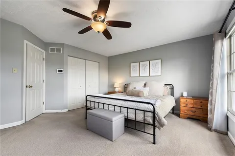 a bed room with a bed and a ceiling fan