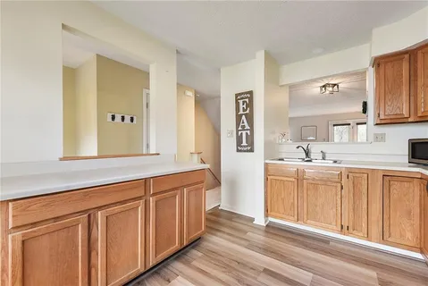a spacious bathroom with double vanity sink a two mirror a lamp a vanity and a window