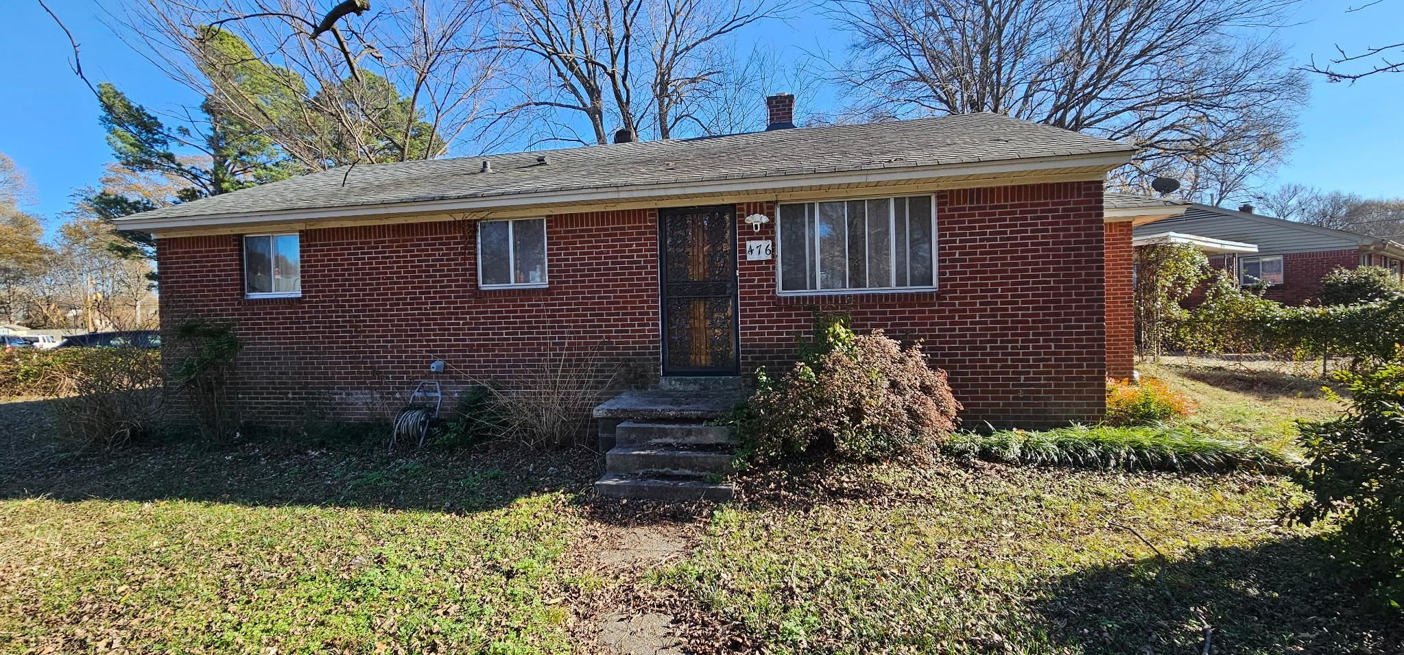 476 McDermitt Road Memphis, TN 38120 - Photo 1 of 1 View of front facade featuring brick siding, a chimney, and a front lawn