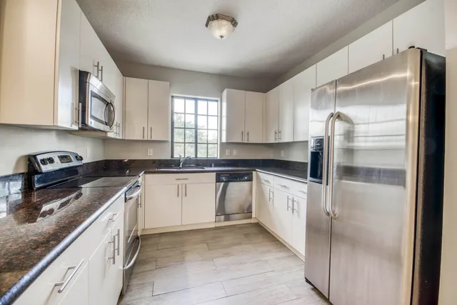 a kitchen with stainless steel appliances granite countertop a stove a sink and a microwave