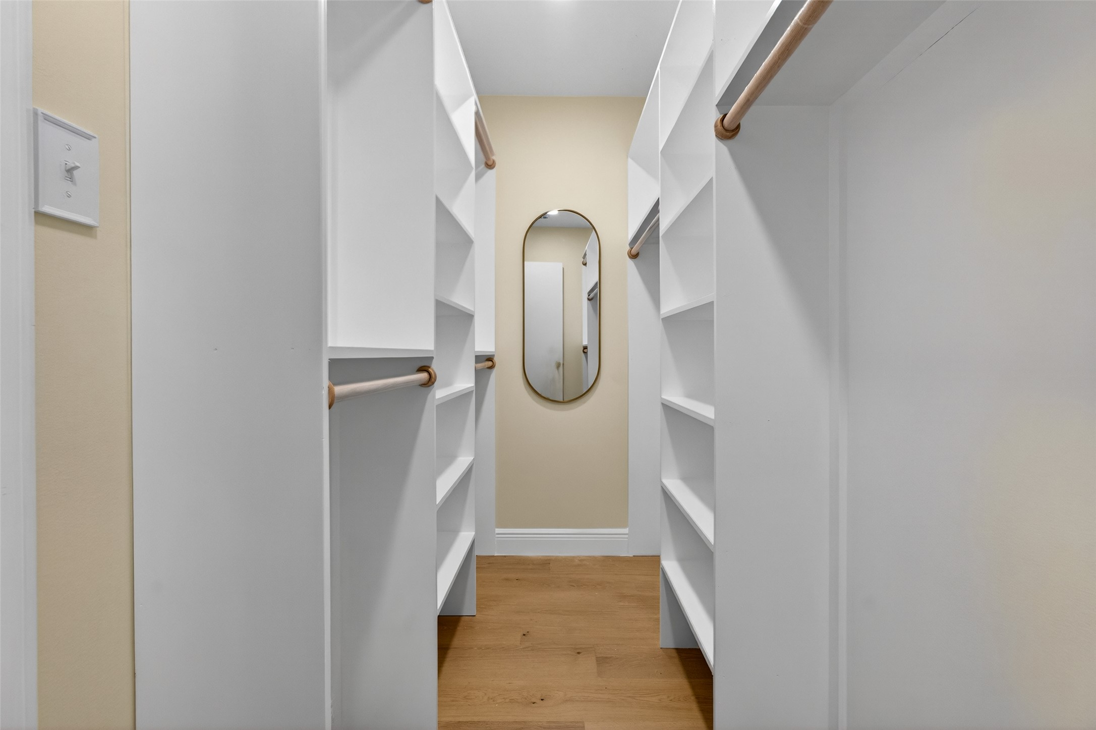 6806 Rearden Road Austin, TX 78745 - Photo 16 of 28 Walk-in closet featuring wood-finish flooring, recessed lighting, and a full-length wall mirror