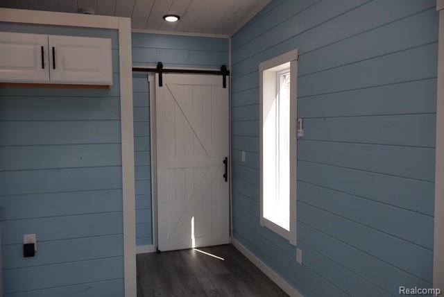 1545 South La Chance Road Lake City, MI 49651 - Photo 29 of 51 Entryway featuring a barn door, wood walls, dark wood-style floors, and wood ceiling