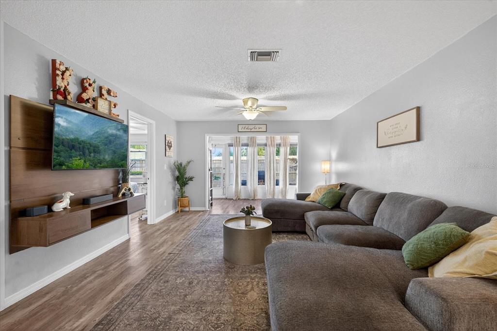 3230 Teeside Drive New Port Richey, FL 34655 - Photo 4 of 31 a living room with furniture a flat screen tv and a large window