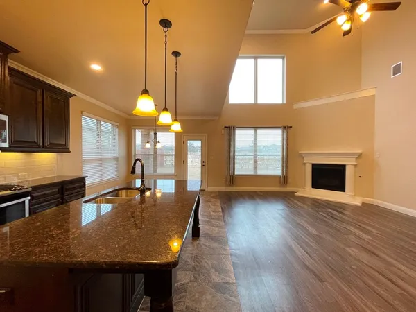 a dining room with wooden floor a chandelier a wooden table and chairs