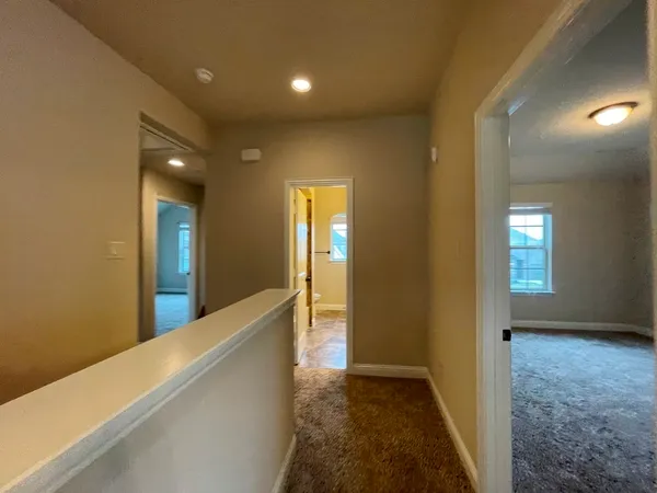 a bedroom with a bed and a potted plant on the dresser